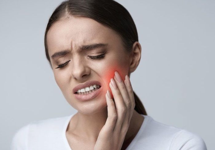 Woman holding her jaw in pain from a toothache, emergency dentist in Madeira Beach, FL